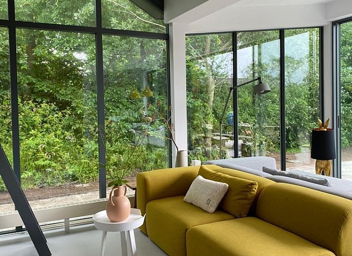 Geraeumige Terrasse im Ferienhaus De Koerie in De Koog, Texel, umgeben von gruener Natur.