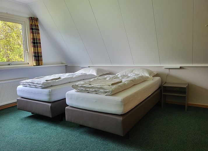 Gezellige woonkamer in Agter Mienterglop - Vakantiehuis 5103, Texel, met comfortabele zithoek en haard.