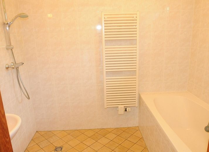 Gezellige woonkamer in Agter Mienterglop - Vakantiehuis 5103, Texel, met comfortabele zithoek en haard.