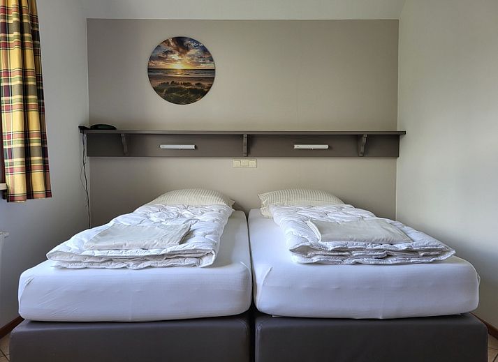 Gezellige woonkamer in Agter Mienterglop - Vakantiehuis 5103, Texel, met comfortabele zithoek en haard.