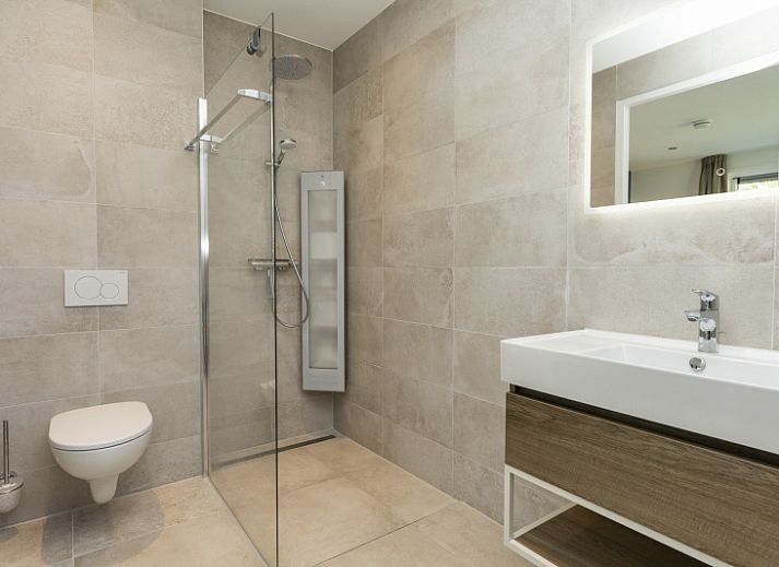 Ruime woonkamer van Villa 15 in De Koog, Texel, met veel lichtinval en een gezellige zithoek op de Waddeneilanden.