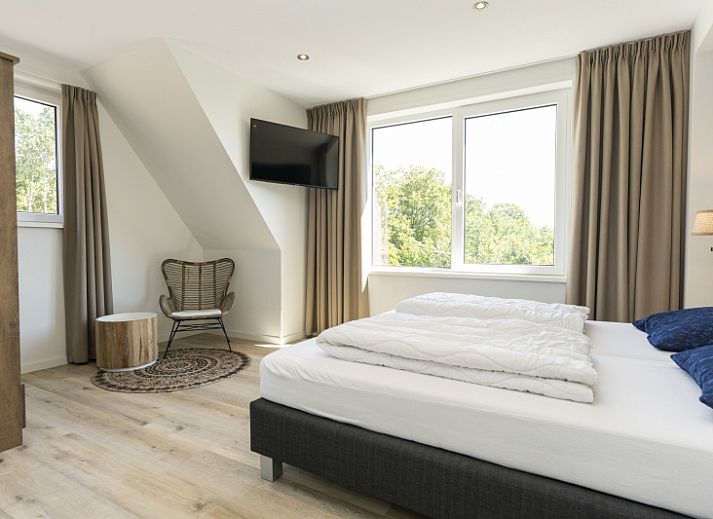 Ruime woonkamer van Villa 15 in De Koog, Texel, met veel lichtinval en een gezellige zithoek op de Waddeneilanden.