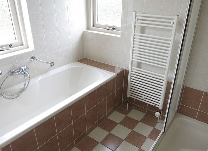 Bungalow 35 in De Koog, Texel biedt een charmant terras met zitgelegenheid omringd door groene natuur.