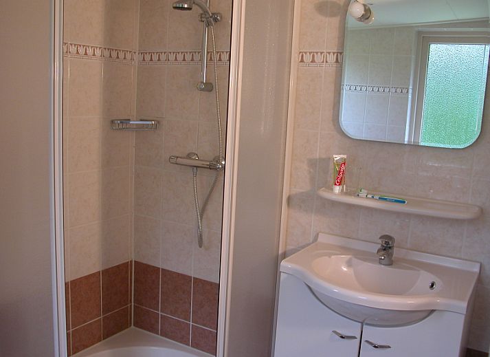 Bungalow 35 in De Koog, Texel biedt een charmant terras met zitgelegenheid omringd door groene natuur.