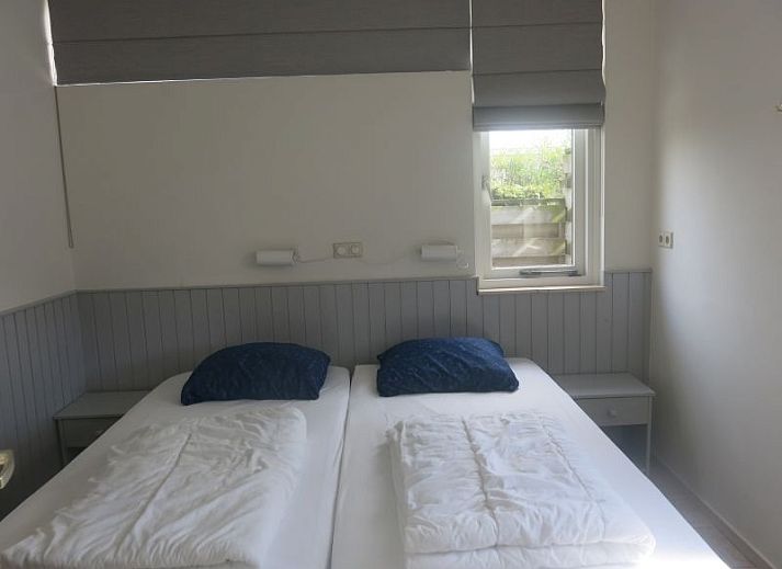 Moderne badkamer in Bungalow 35, De Koog, Texel met ligbad en grote ramen voor natuurlijk licht.