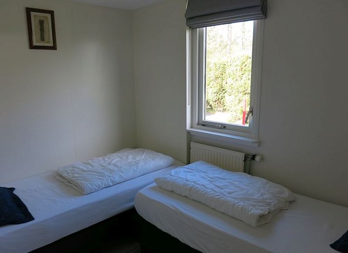 Moderne badkamer in Bungalow 35, De Koog, Texel met ligbad en grote ramen voor natuurlijk licht.