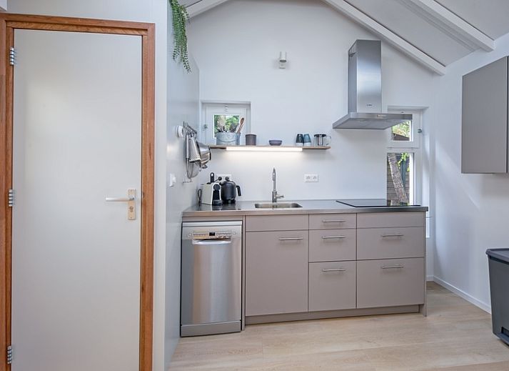 Lichte zithoek in vakantiehuis Pippa, De Koog, Texel met comfortabele bank en eettafel.