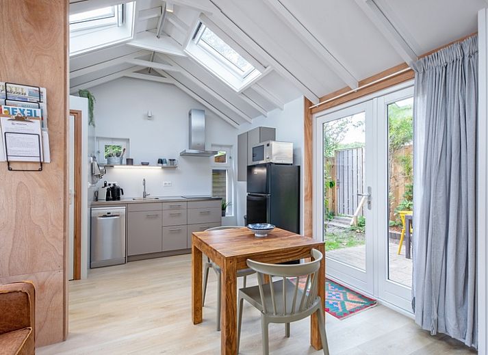 Lichte zithoek in vakantiehuis Pippa, De Koog, Texel met comfortabele bank en eettafel.