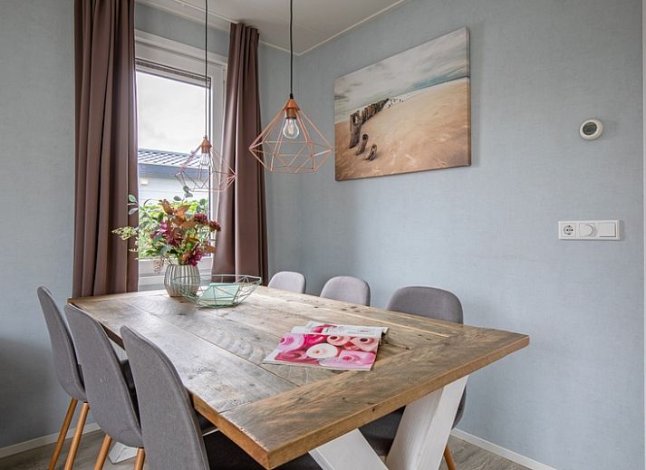 Buitenkant van Chalet Bregkoog 261 bij Chaletpark Bregkoog, De Koog, Texel, sfeervol verlicht in de avond.