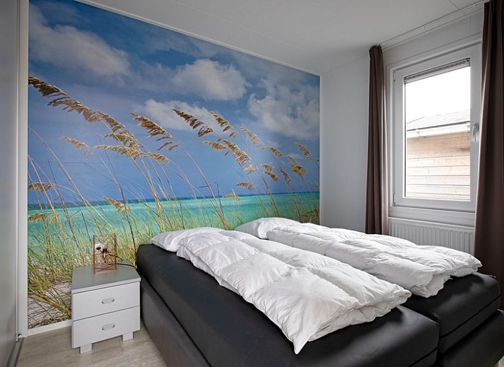 Buitenkant van Chalet Bregkoog 261 bij Chaletpark Bregkoog, De Koog, Texel, sfeervol verlicht in de avond.