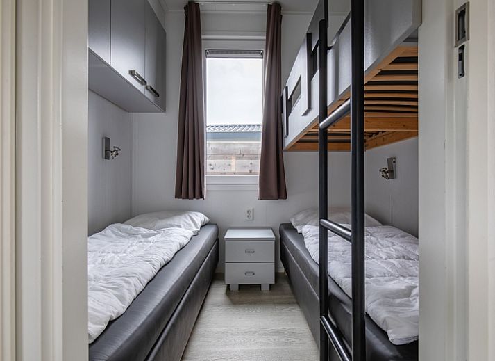 Buitenkant van Chalet Bregkoog 261 bij Chaletpark Bregkoog, De Koog, Texel, sfeervol verlicht in de avond.