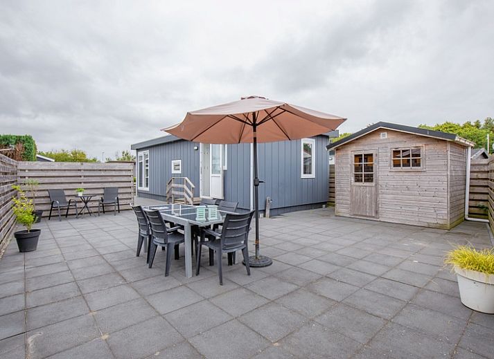 Buitenkant van Chalet Bregkoog 261 bij Chaletpark Bregkoog, De Koog, Texel, sfeervol verlicht in de avond.