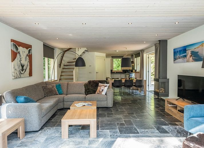 Gezellige woonkamer van Westenwind in De Koog, Texel, met comfortabele banken en uitzicht op de tuin.