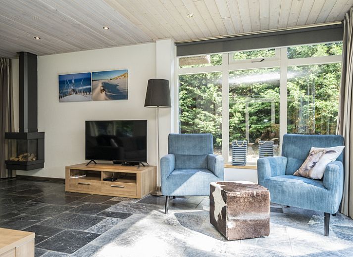 Gezellige woonkamer van Westenwind in De Koog, Texel, met comfortabele banken en uitzicht op de tuin.