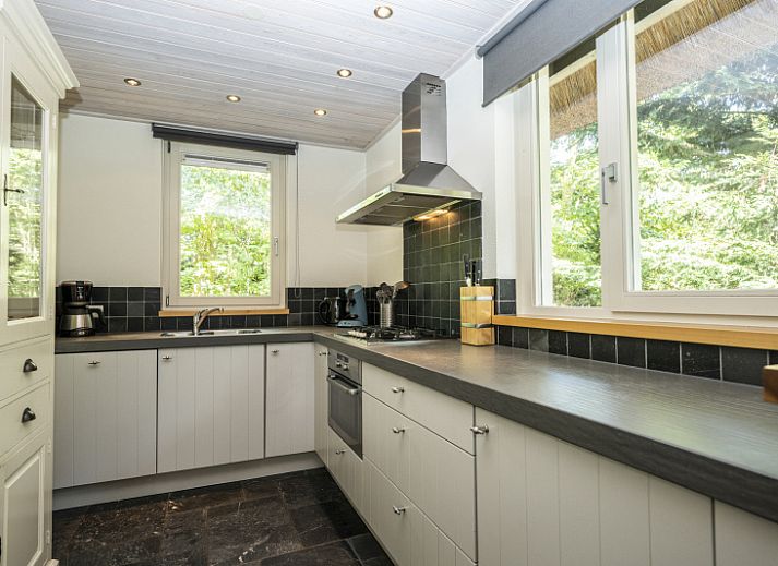 Gezellige woonkamer van Westenwind in De Koog, Texel, met comfortabele banken en uitzicht op de tuin.