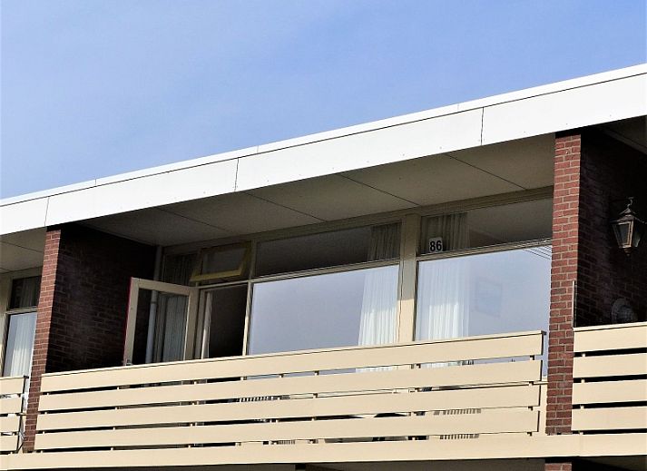 't Kerckeland - Appartement Kerckeland 86, De Koog, Texel, biedt een ruim balkon met uitzicht op de groene omgeving van de Waddeneilanden.