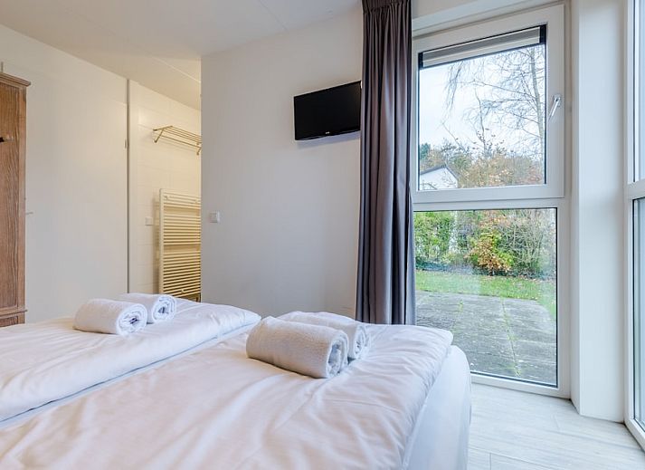 Slaapkamer in bungalow Schilpbanck 4, De Koog, Texel met houten kast en grote ramen voor een lichte, rustige sfeer op de Waddeneilanden.