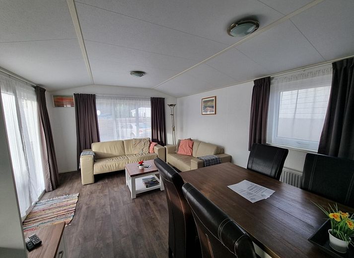 Buitenzijde van Chalet Bregkoog 54 MaMaMia in De Koog, Texel met ruim terras en houten schutting.