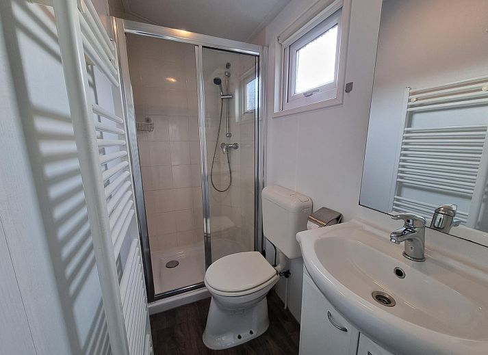 Buitenzijde van Chalet Bregkoog 54 MaMaMia in De Koog, Texel met ruim terras en houten schutting.