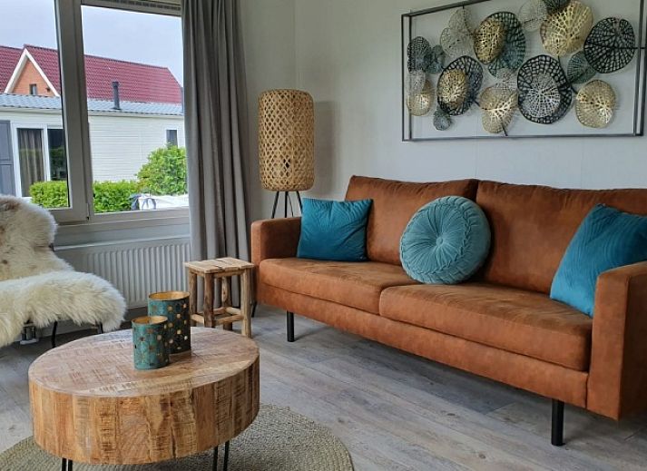 Chalet Bregkoog 154 in De Koog op Texel met groene tuin en houten hekwerk.