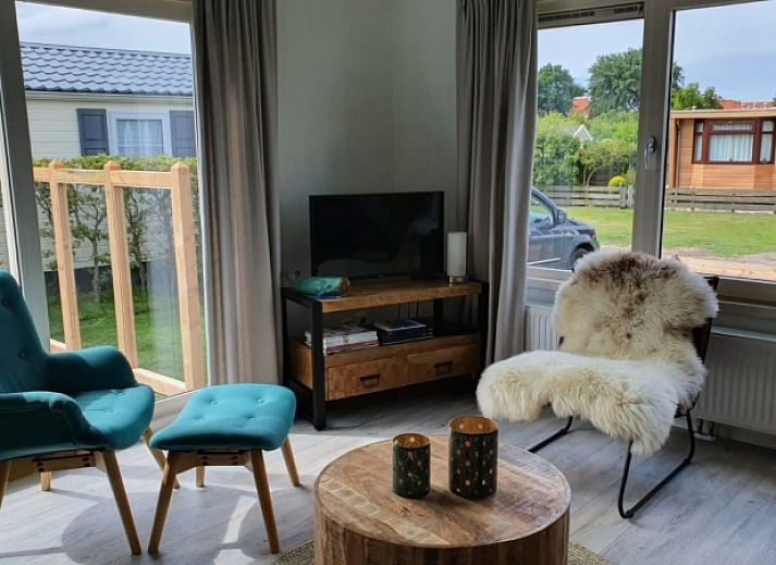 Chalet Bregkoog 154 in De Koog op Texel met groene tuin en houten hekwerk.