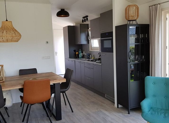 Chalet Bregkoog 154 in De Koog op Texel met groene tuin en houten hekwerk.