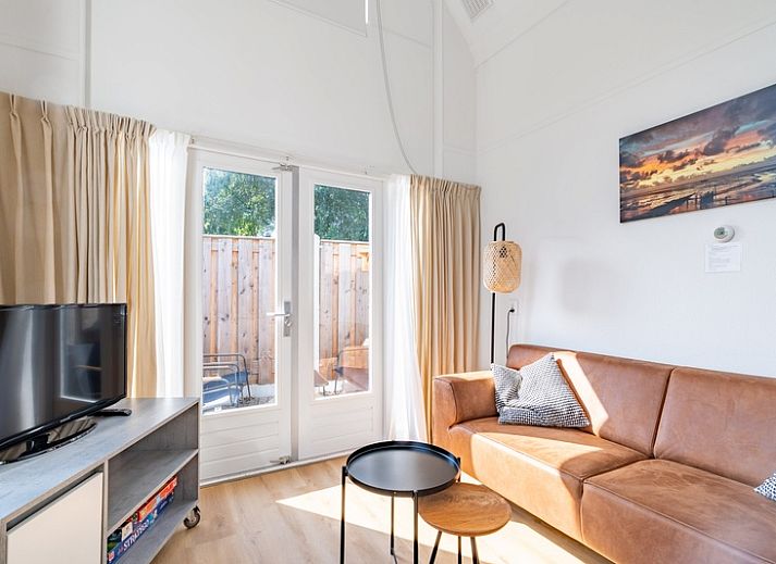 Lichte woonkamer in vakantiehuis Plevierstraat 3a, De Koog, Texel, met moderne inrichting en wenteltrap.