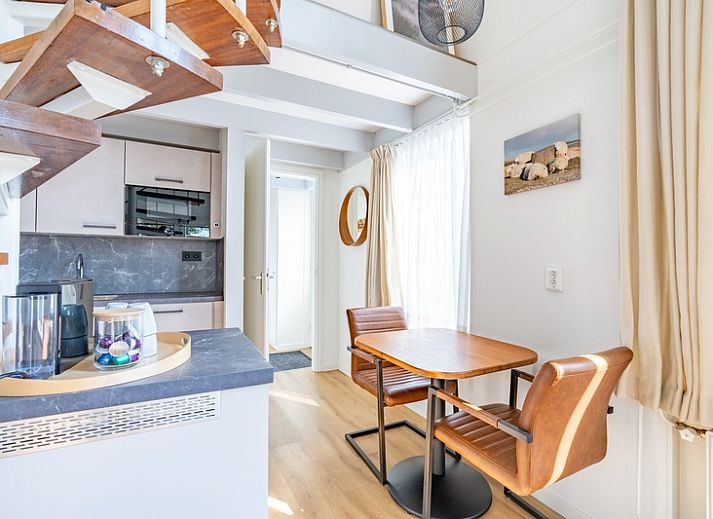 Lichte woonkamer in vakantiehuis Plevierstraat 3a, De Koog, Texel, met moderne inrichting en wenteltrap.