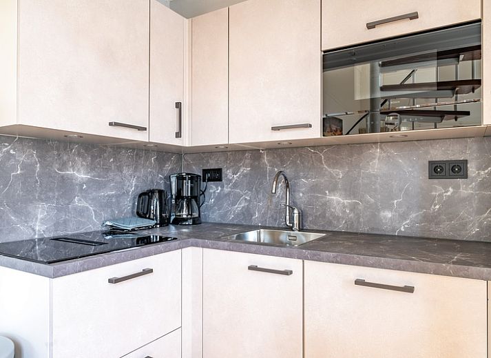 Gezellige zitruimte in vakantiehuis Plevierstraat 3a, De Koog, Texel, met comfortabele bank en veel daglicht.