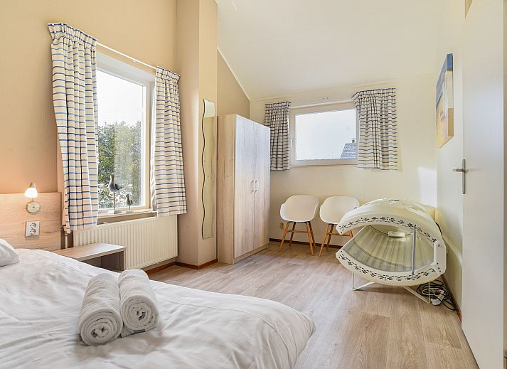 Gezellige woonkamer in Beach Park Texel 6-persoons villa, De Koog, met comfortabele banken en open haard.