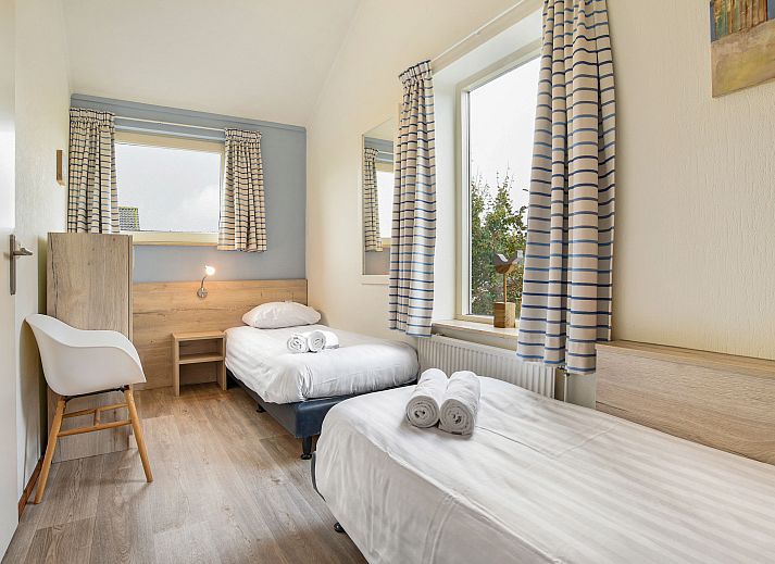 Gezellige woonkamer in Beach Park Texel 6-persoons villa, De Koog, met comfortabele banken en open haard.