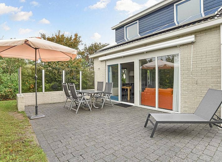 Gezellige woonkamer in Beach Park Texel 6-persoons villa, De Koog, met comfortabele banken en open haard.