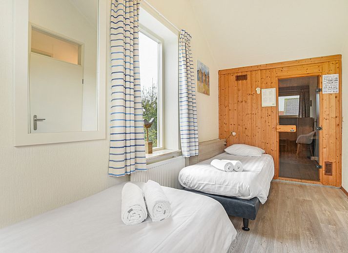 Eet- en zithoek in Beach Park Texel 6-persoons villa, De Koog, met toegang tot het terras.