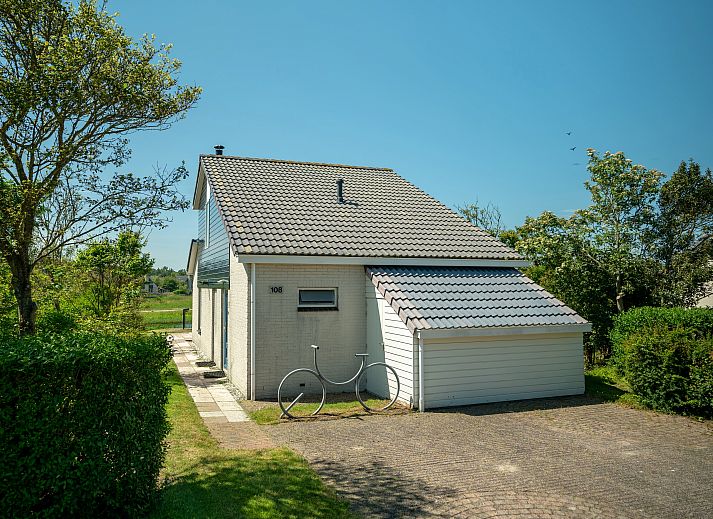 Eet- en zithoek in Beach Park Texel 6-persoons villa, De Koog, met toegang tot het terras.