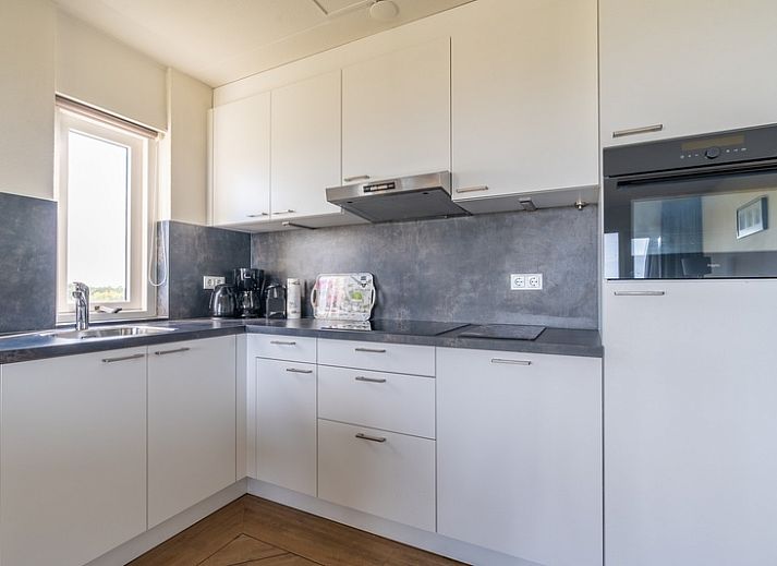 Lichte zithoek in Appartement Juliana 118 Zeezicht, De Koog, Texel met comfortabele banken en zeezicht.