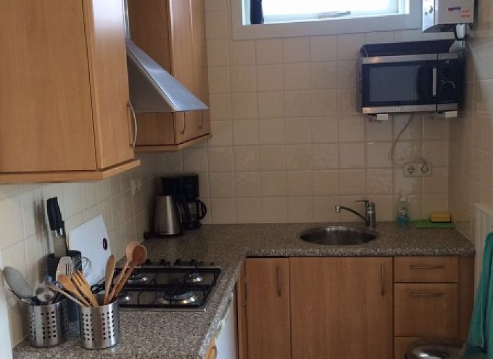 Gezellige woonkamer van Zomerhuisje Plevierstraat 12 in De Koog, Texel, met comfortabele zithoek en eethoek, ideaal voor een ontspannen verblijf.