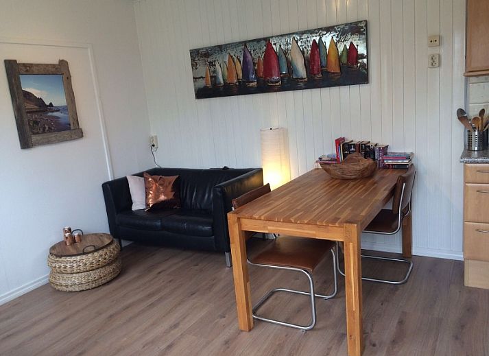 Gezellige woonkamer van Zomerhuisje Plevierstraat 12 in De Koog, Texel, met comfortabele zithoek en eethoek, ideaal voor een ontspannen verblijf.
