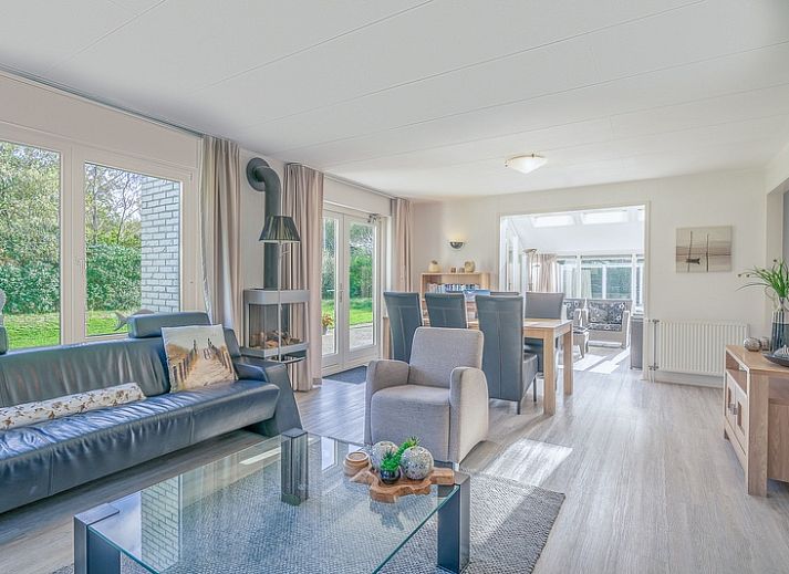 Achteraanzicht van Vakantiehuis Kamperfoelie 83 met sauna in De Koog Texel, omgeven door groen.