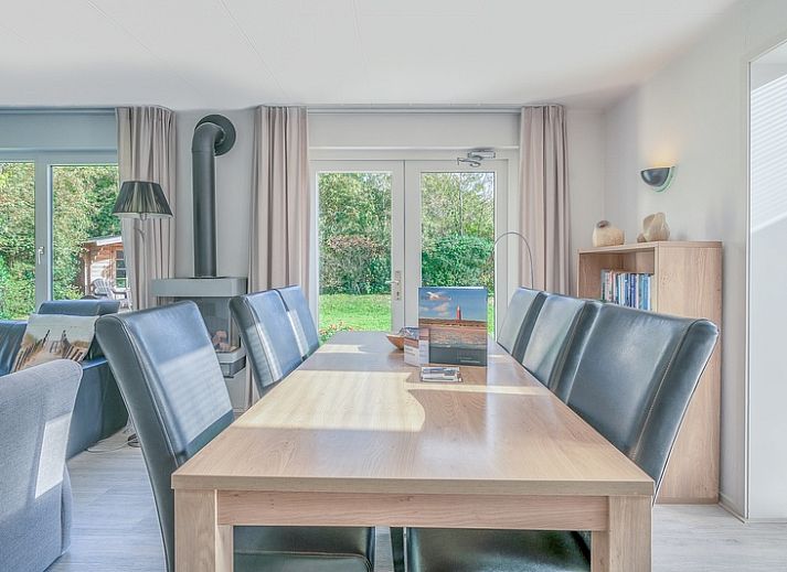 Achteraanzicht van Vakantiehuis Kamperfoelie 83 met sauna in De Koog Texel, omgeven door groen.