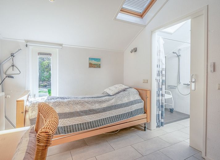 Achteraanzicht van Vakantiehuis Kamperfoelie 83 met sauna in De Koog Texel, omgeven door groen.