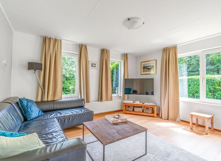 Geraeumige Terrasse im Ferienhaus Kamperfoelie 85 in De Koog, Texel mit bequemen Liegestuehlen und Esstisch.