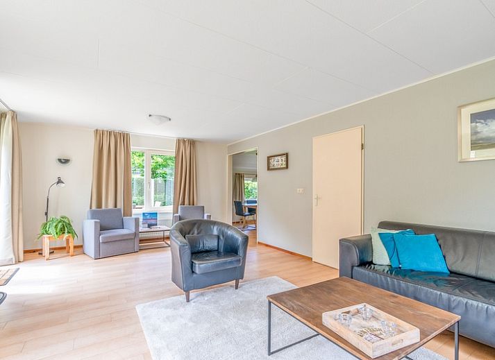 Geraeumige Terrasse im Ferienhaus Kamperfoelie 85 in De Koog, Texel mit bequemen Liegestuehlen und Esstisch.