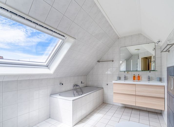 Gemuetliches Wohnzimmer im Ferienhaus Kamperfoelie 85, De Koog, Texel mit grossen Fenstern und bequemer Sitzecke.