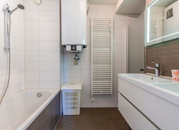 Spacious living room of Apartment Juliana 120 Eilandzicht, De Koog, Texel with beach decorations and comfortable chairs.