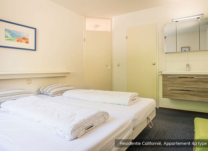 Slaapkamer in Type 4 vakantiehuis, De Koog Texel, met twee eenpersoonsbedden en een schilderij aan de muur.