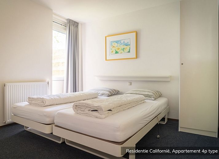 Slaapkamer in Type 4 vakantiehuis, De Koog Texel, met twee eenpersoonsbedden en een schilderij aan de muur.