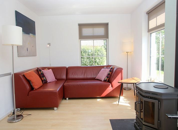 T8A bungalow in De Koog, Texel met charmant rieten dak en kleurrijke luiken, ideaal voor een ontspannen vakantie op de Waddeneilanden.