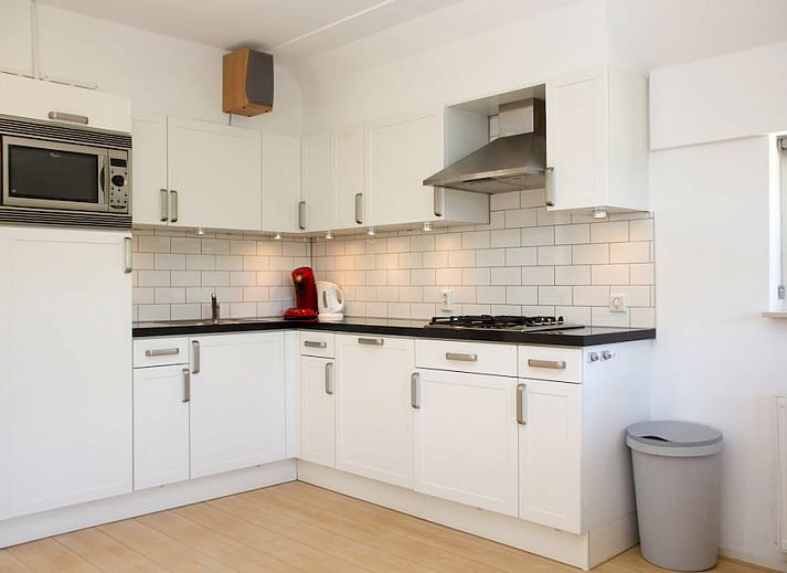 T8A bungalow in De Koog, Texel met charmant rieten dak en kleurrijke luiken, ideaal voor een ontspannen vakantie op de Waddeneilanden.