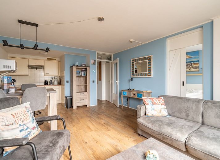 Gezellige woonkamer in Appartement Juliana 076 Eilandzicht, De Koog, Texel met uitzicht op terras en natuur.