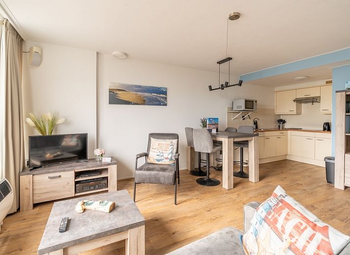 Gezellige woonkamer in Appartement Juliana 076 Eilandzicht, De Koog, Texel met uitzicht op terras en natuur.